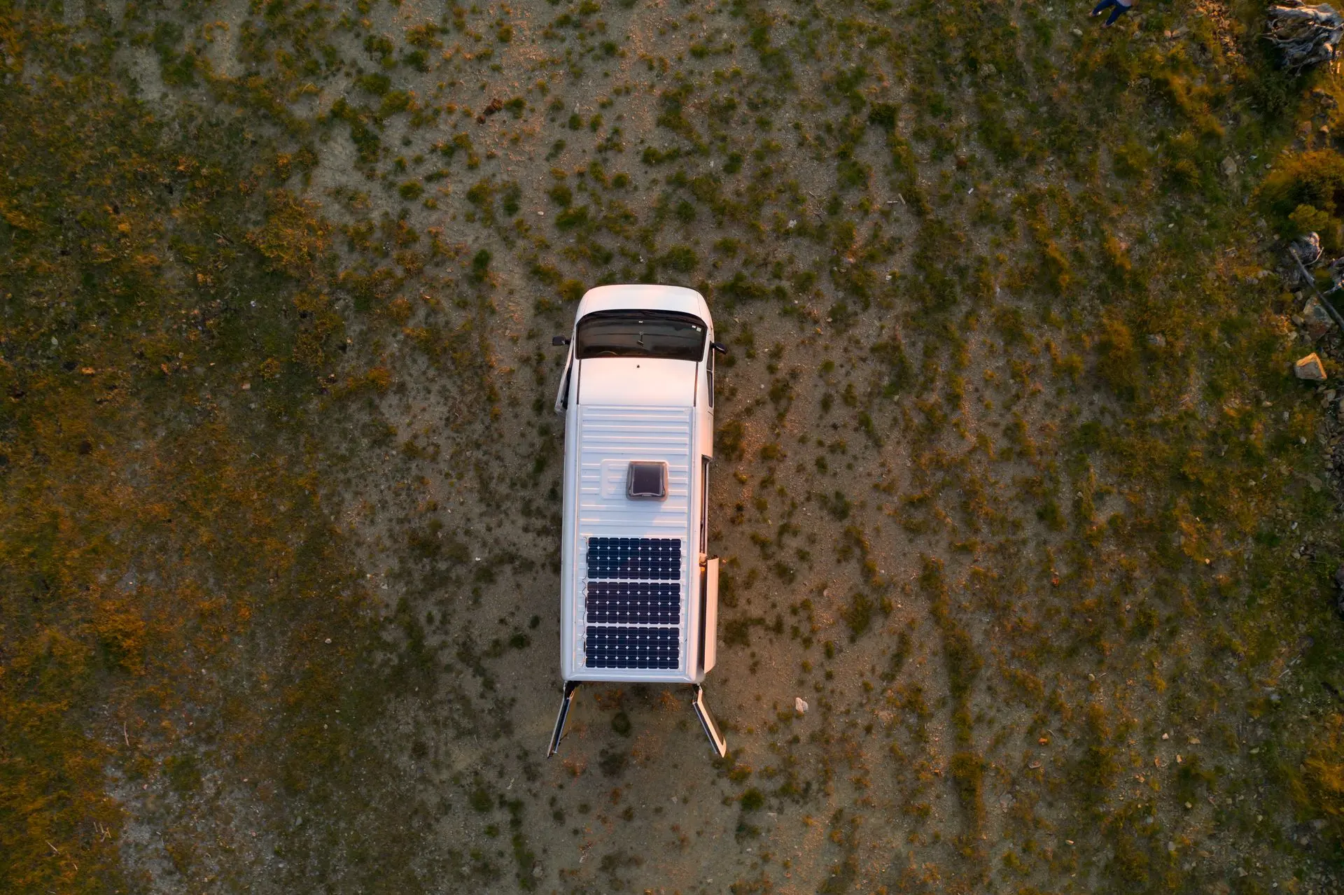 Caravan with solar panels in field